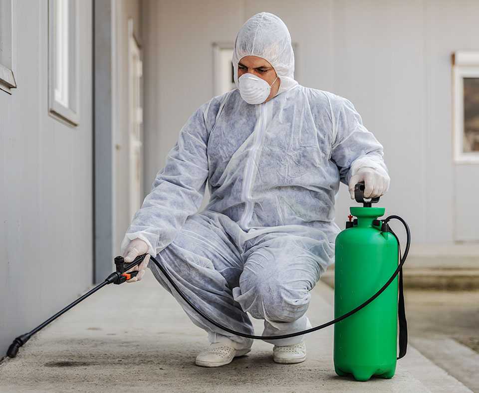 Pest Defenders technician treating a property exterior